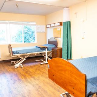A view of a hospital patient room with two beds, showcasing a clean and well-lit environment.