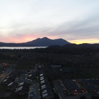 A serene sunset view over the mountains and a tranquil body of water.