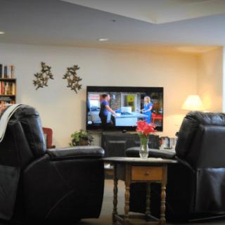 A cozy living room with recliner chairs facing a television.