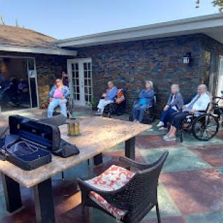 Seniors enjoying a sunny day outdoors at a care facility.