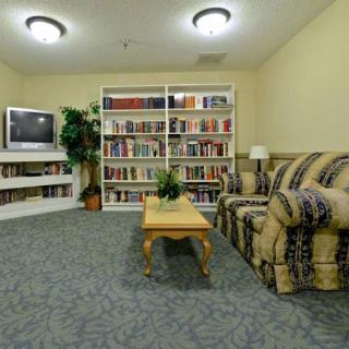 A cozy living room with a sofa, television, and bookshelves filled with books.
