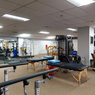 An indoor gym with various exercise equipment, including training benches and machines.