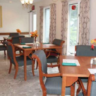 A cozy dining area with neatly arranged tables and chairs, featuring elegant decor.