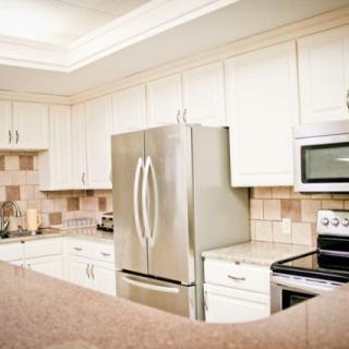 A modern kitchen with stainless steel appliances and white cabinetry.