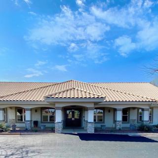 A single-story building with a tiled roof under a partly cloudy sky.