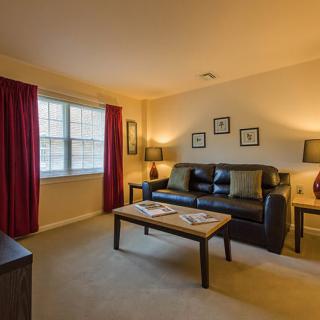 A cozy living room with a black sofa, coffee table, and warm lighting.