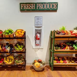 A vibrant display of fresh produce including fruits and vegetables arranged on shelves in a grocery store.