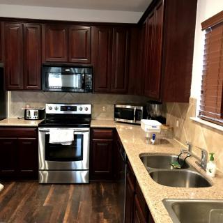 A modern kitchen with dark wood cabinets and stainless steel appliances.