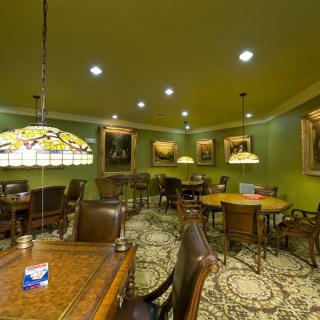A cozy lounge area with elegant furniture and classic artwork on the walls.