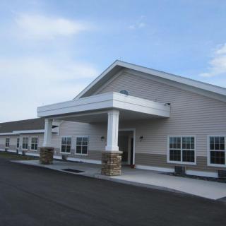 A modern commercial building with a prominent entrance and a paved walkway.