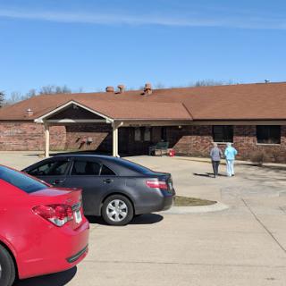 Healthcare workers outside a facility on a sunny day.