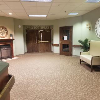 A spacious lobby with a carpeted floor, featuring seating and decor.