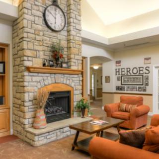 A cozy living room with a stone fireplace and warm-toned furniture.