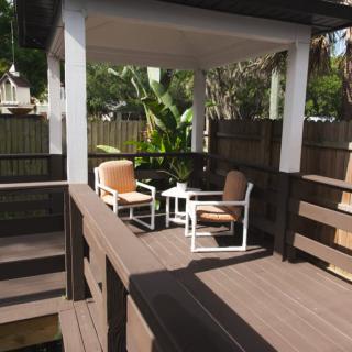 Outdoor patio with chairs and a small table on a wooden deck.