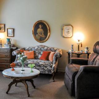 A cozy vintage-style living room with patterned furniture, decorative pillows, and a warm ambiance.