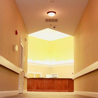 A well-lit hallway leading to a reception area with warm lighting.