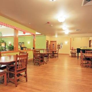 A spacious restaurant dining area with wooden furniture and warm lighting.