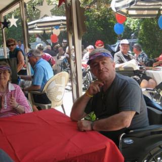 People sitting at a decorated outdoor event, enjoying a festive atmosphere.