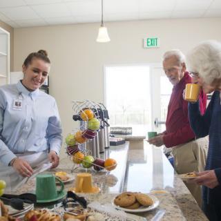 People enjoying coffee and snacks in a cafeteria setting.