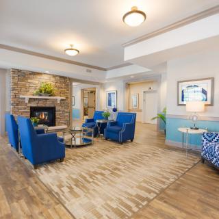 A modern living room with blue chairs and a fireplace, showcasing elegant interior design.