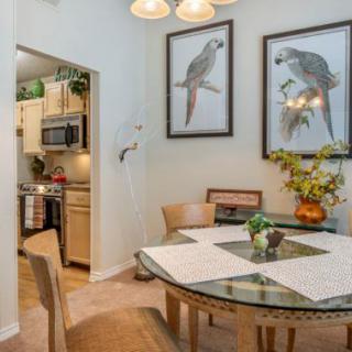 A cozy dining area with bird-themed artwork and a view into the kitchen.