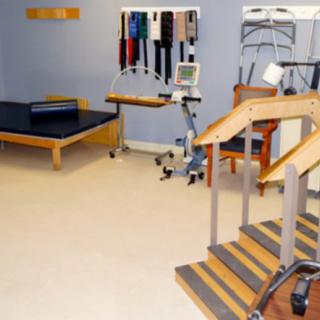 A physical therapy room equipped with exercise equipment and a small staircase for rehabilitation exercises.