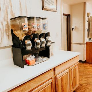 A snack dispenser filled with various treats, placed on a countertop in a cozy kitchen setting.