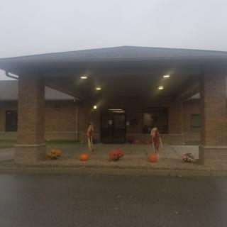 Entrance of a community center decorated for fall with pumpkins.