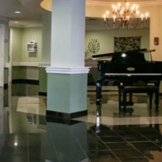 An elegant lobby featuring a grand piano and chandelier.