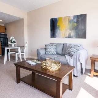 A cozy living room with stylish decor, featuring a sofa, coffee table, and abstract artwork.