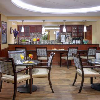 A cozy cafe interior with several tables and chairs, featuring modern decor and warm lighting.