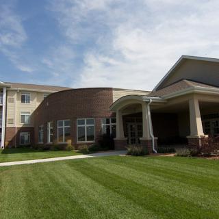 A modern building with a well-maintained lawn and clear skies.