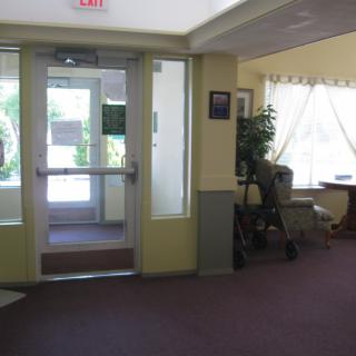 A view of an interior entrance area with a door, large window, and seating.