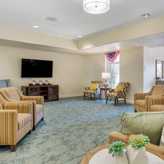 A cozy living room with armchairs, a TV, and elegant decor.