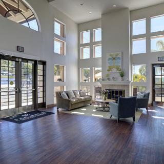 A spacious and well-lit lobby area with modern furniture and large windows.