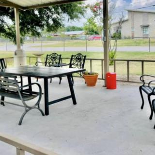 A cozy outdoor patio with a table and chairs, surrounded by potted plants.