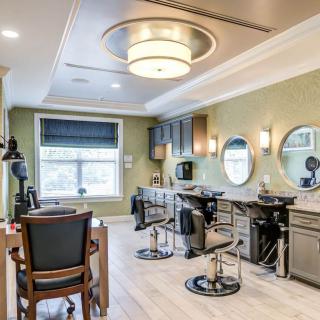 A modern hair salon interior featuring stylish decor with mirrors, barber chairs, and ambient lighting.
