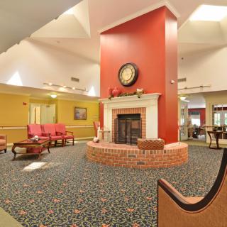 A cozy and spacious lounge area featuring a central fireplace and comfortable seating.