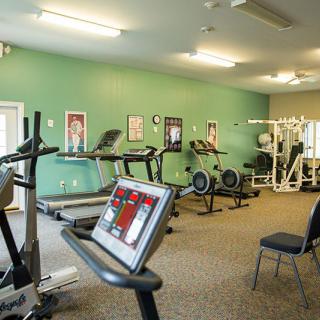 A well-equipped gym featuring treadmills, stationary bikes, and weight machines.