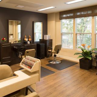 A modern beauty salon with stylish furnishings, mirrors, and indoor plants.