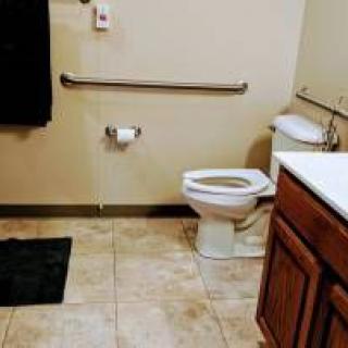 A clean bathroom with a toilet, sink, and black towel.