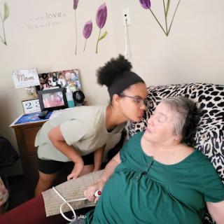 A young adult shares a tender moment with a senior, showcasing their bond and affection.