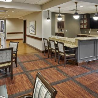 A modern lounge area with a bar, featuring wooden floors, comfortable seating, and elegant lighting.