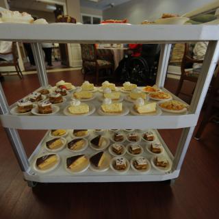 A cart filled with a variety of desserts in a restaurant setting.
