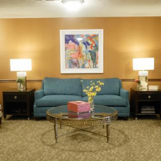 A cozy living room with a blue sofa, decorative artwork, and ambient lighting.