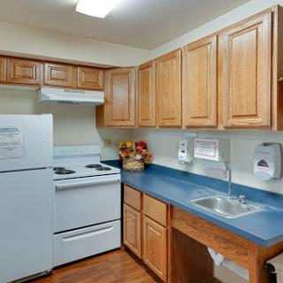A cozy kitchen featuring wooden cabinets, a modern stove, and essential appliances.