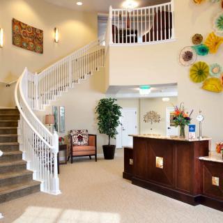 A modern lobby with a sweeping staircase and decorative elements.