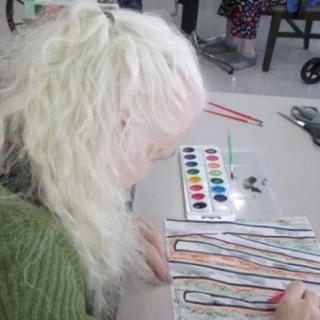 Person engaged in watercolor painting activity.