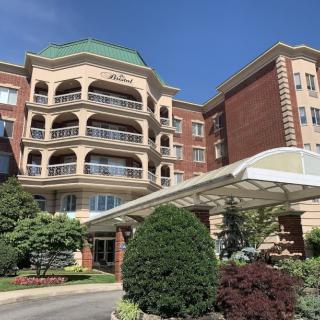 A luxurious hotel with a grand entrance and landscaped surroundings.