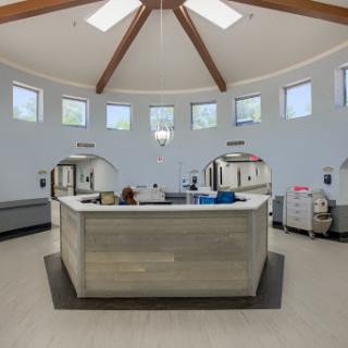 A modern and spacious waiting area in a medical facility, featuring a reception desk and ample natural light.